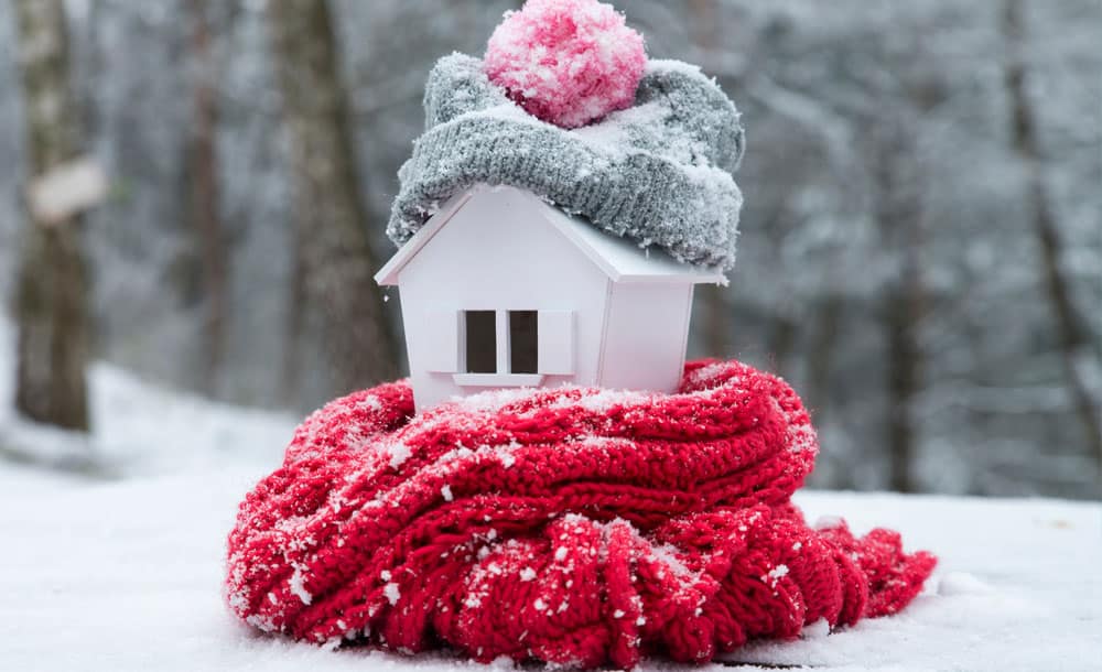 small wooden house wrapped in winter clothes.