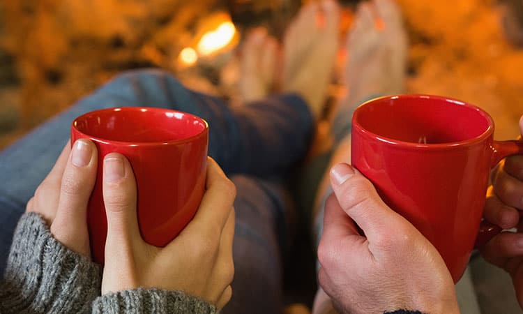 couple holding red mugs.